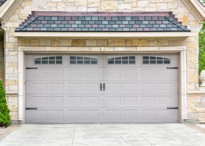 Gray attached garage door with four rectangular glass windows