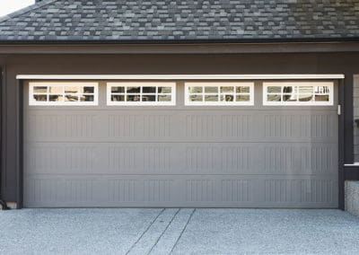 Gray attached garage door with four rectangular glass windows