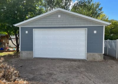 White garage door on a blue detached garage